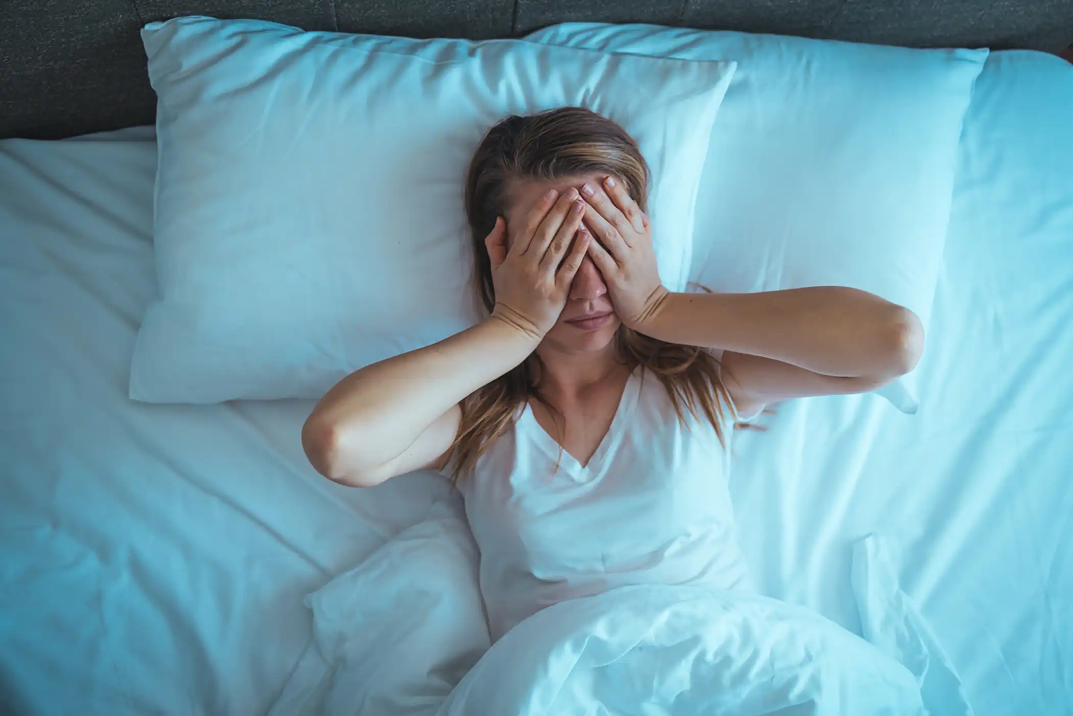 Sleep apnea woman holding hands over face