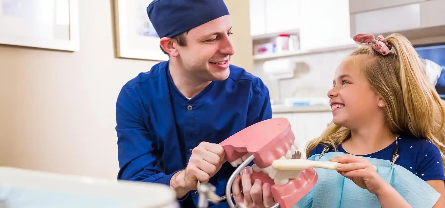 Pediatric Dentistry Girl brushing model of teeth
